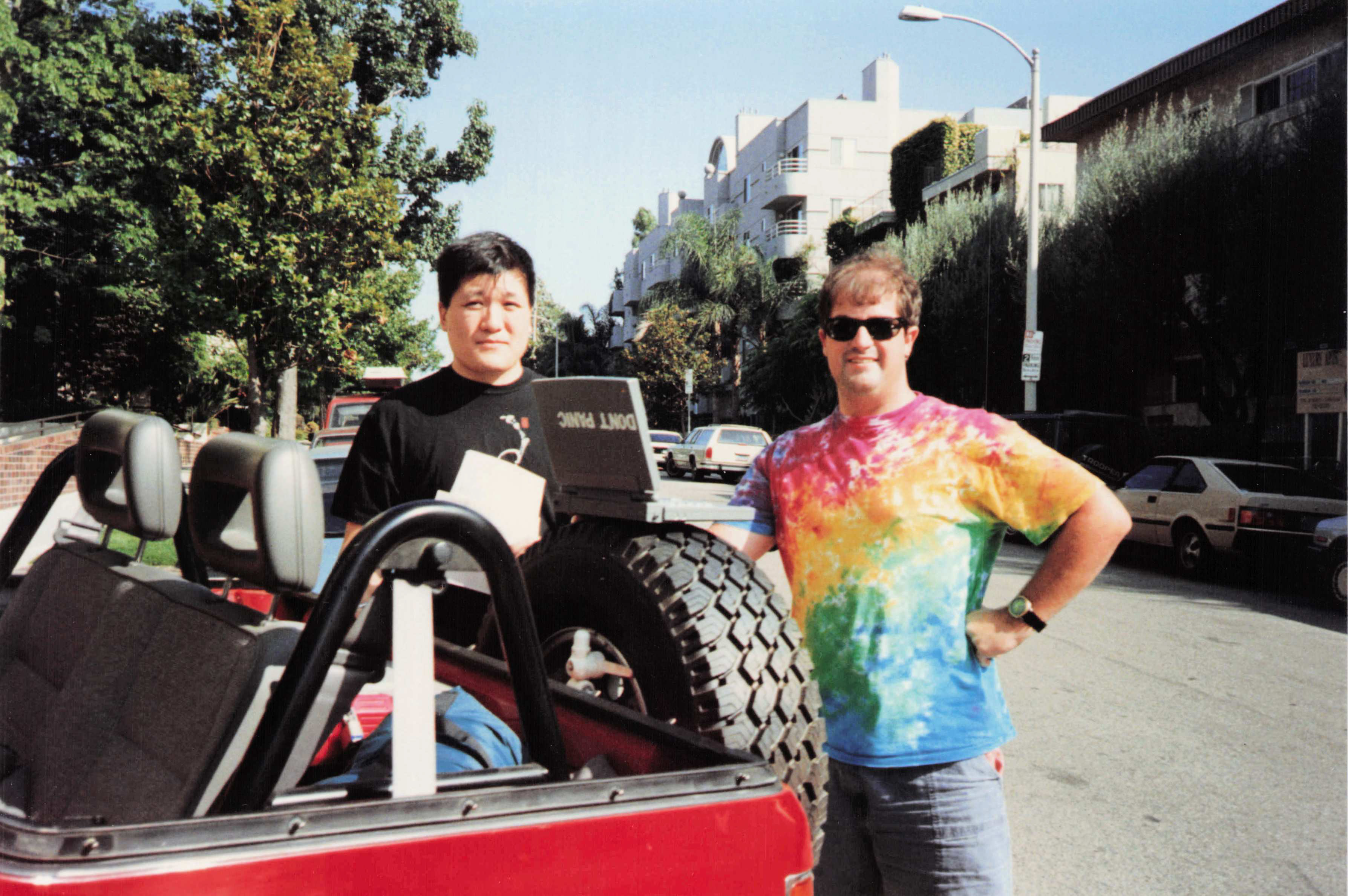 Minsoo and Fred (rainbow tie-dye) beside the Amigo in LA — the DON'T PANIC was on the computer