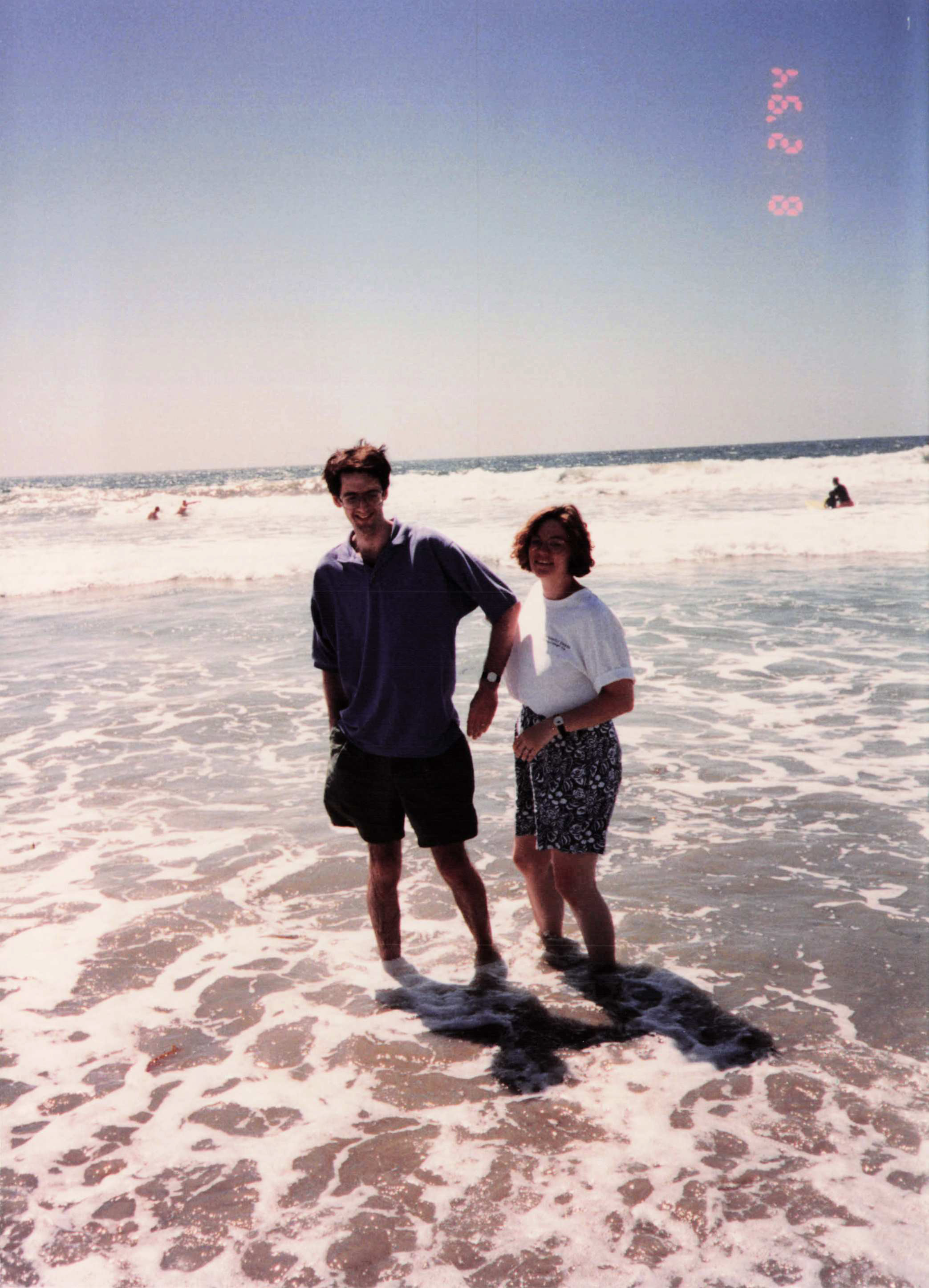Britt and Fred in the surf, both laughing, mid-1990s