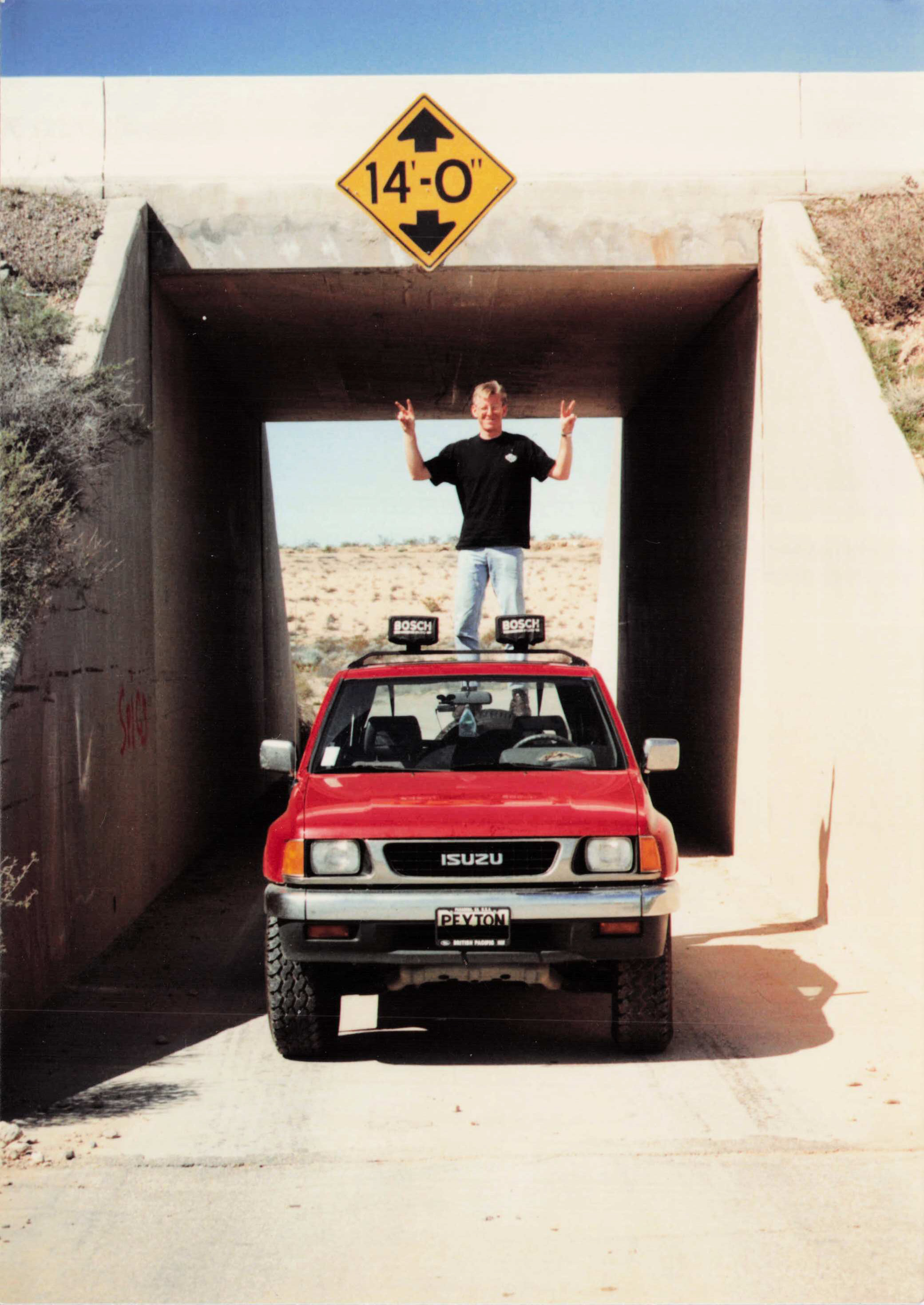 TK on the roof of the Amigo under a 14'0" clearance sign — the logic is impeccable