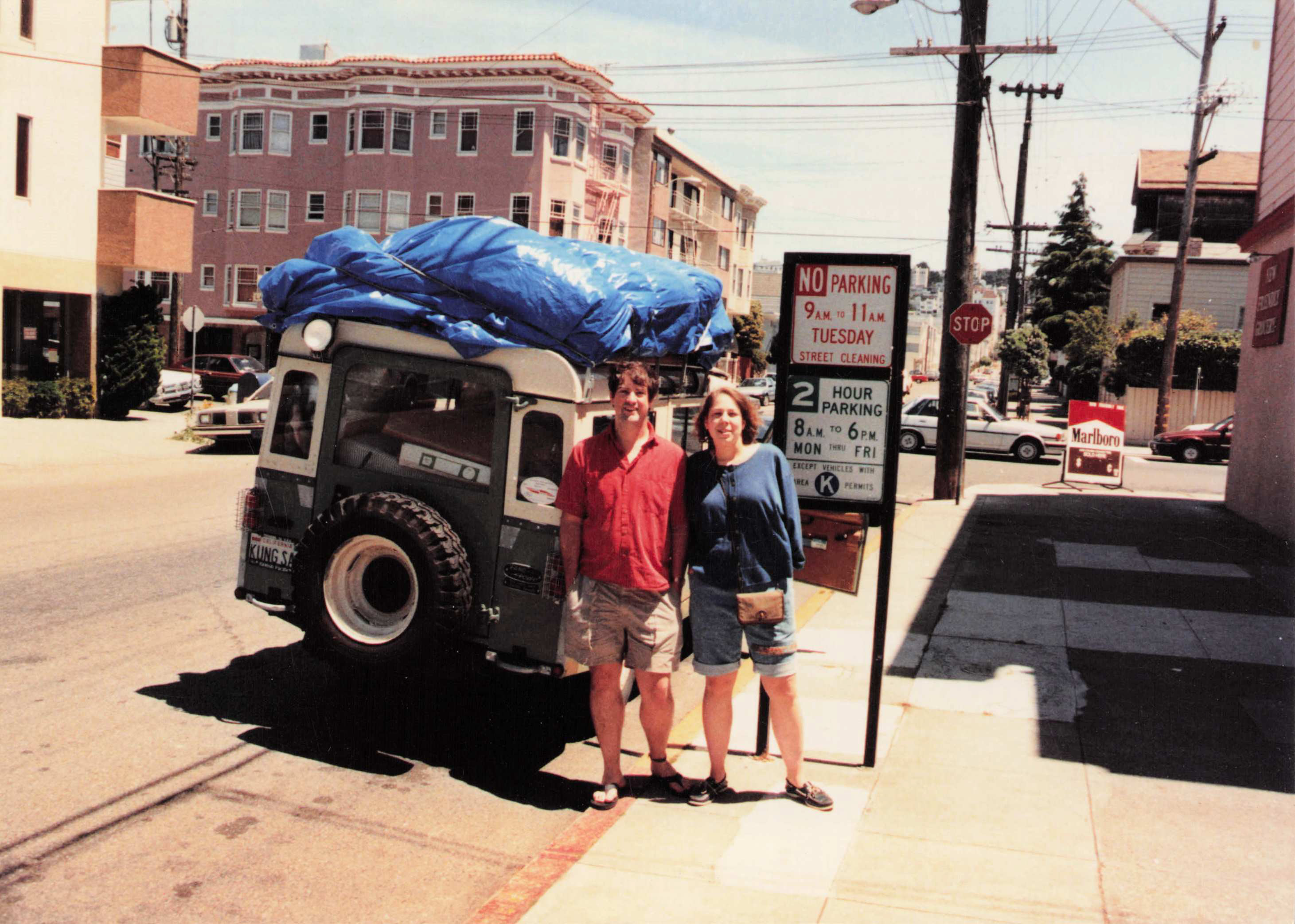 Fred and Susanne Meyer in front of the Land Rover, blue tarp, SF Victorians — about to leave to take Sue to Texas