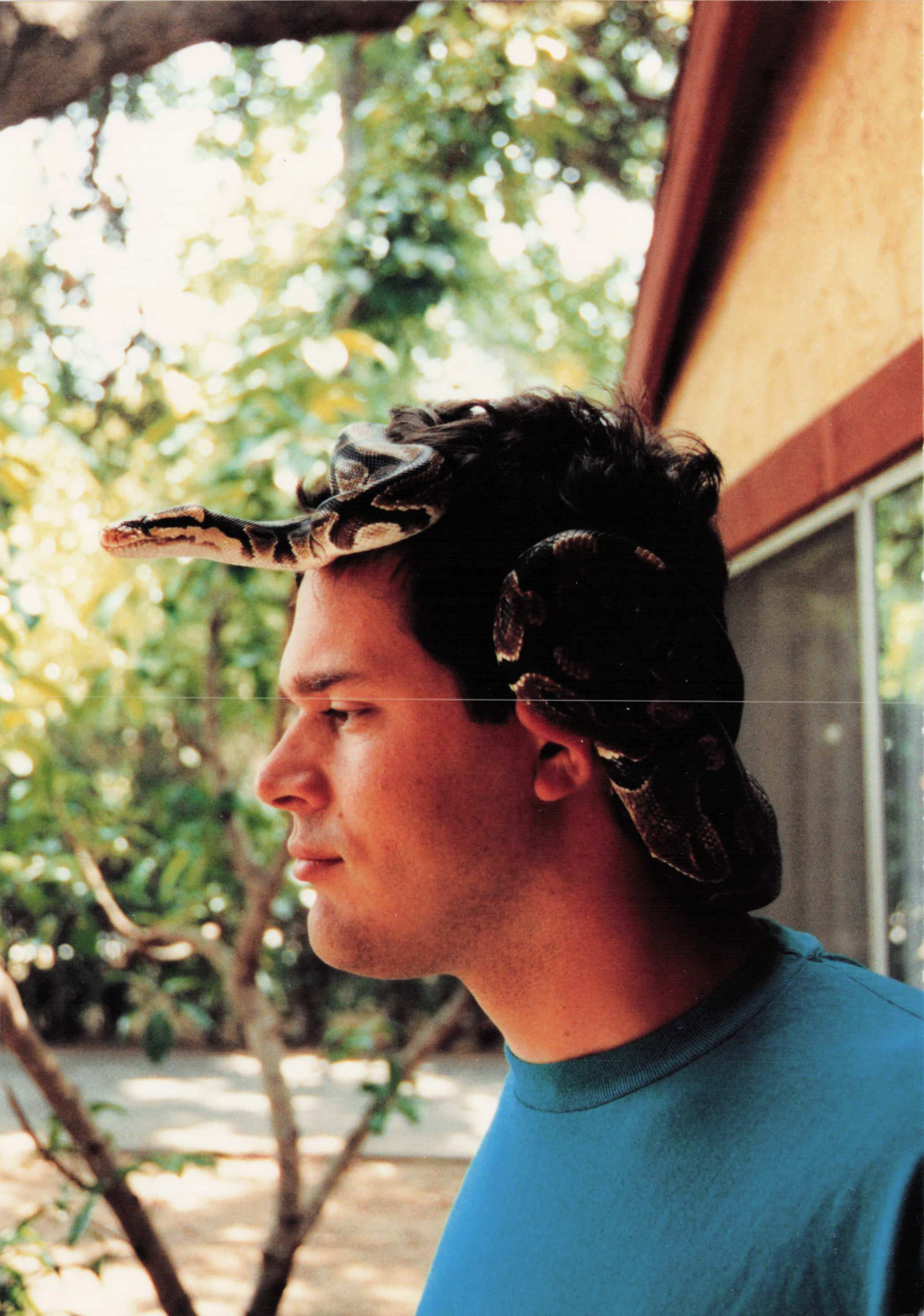 Ault with Basil the ball python draped over his head