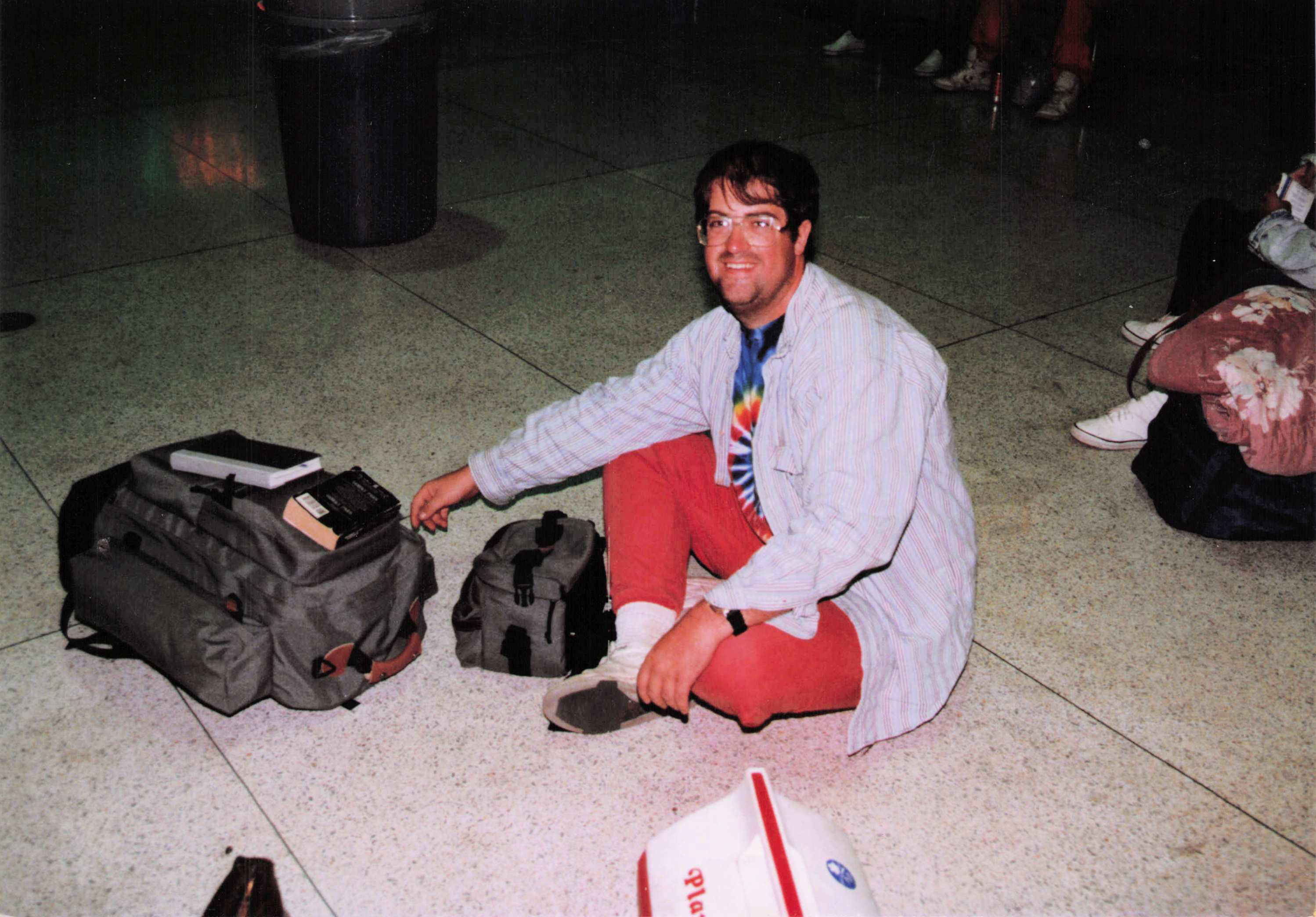 Fred at the Greyhound station in Salt Lake City — tie-dye, red pants, surrounded by bags