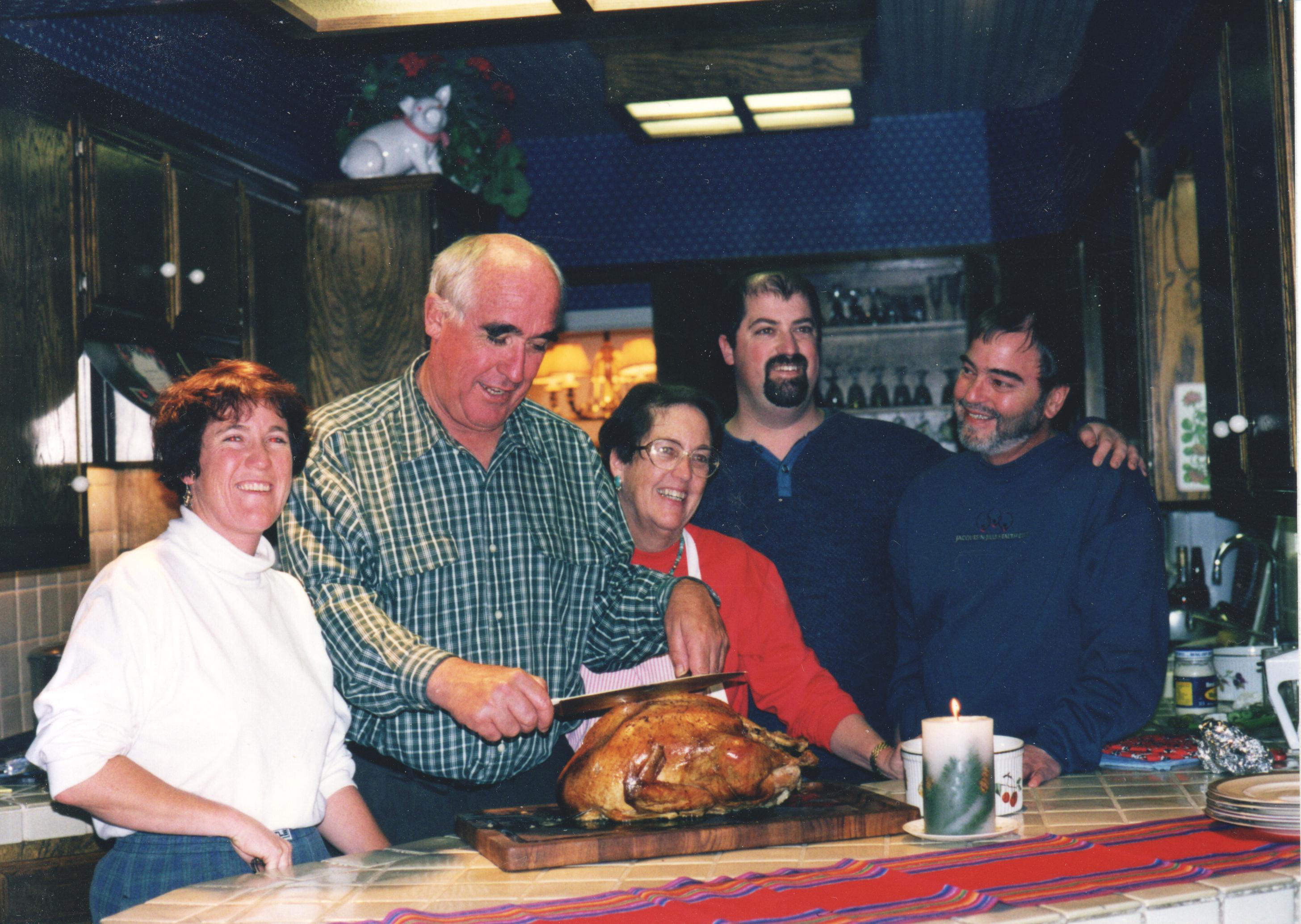 A Heald family gathering, late 1990s or early 2000s — Elise in the red sweater, Phil carving, Fred bearded at the back. The photo is tagged with Harry, though his place in the frame isn't pinned down.