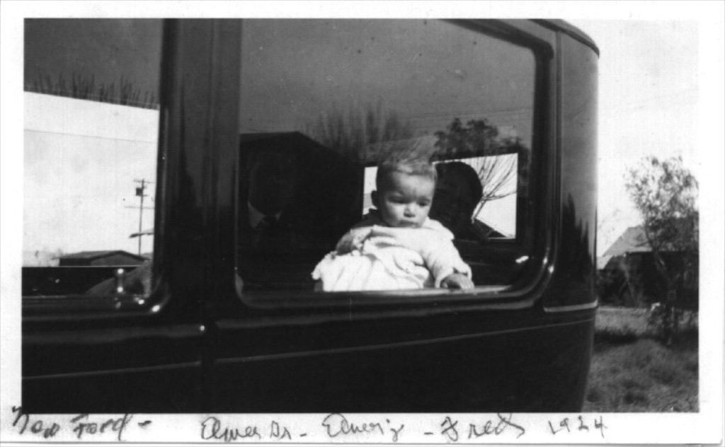 Baby Elmer Jr. peering out the window of the family's new Ford — handwritten note reads 'New Ford — Elmer Sr — Emery — Fred — 1924'